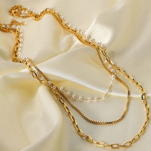 Detailed view of 18K gold plated triple layered necklace with pearls on satin