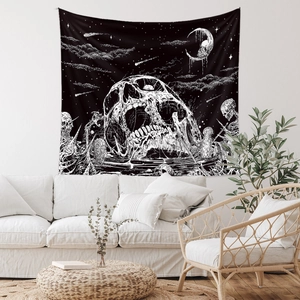 Bohemian skull tapestry with crescent moon and stars hanging on a white living room wall