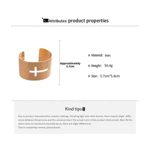 Detail view of a wide gold cuff bracelet featuring hammered texture and a cross cutout design