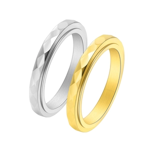 Detailed macro view of geometric faceted diamond-pattern rotating rings in gold and silver