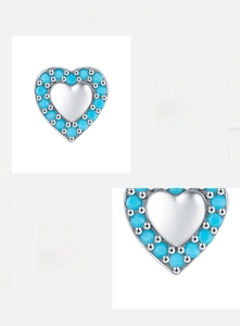 Macro detail of S925 sterling silver heart earrings with inlaid turquoise beads