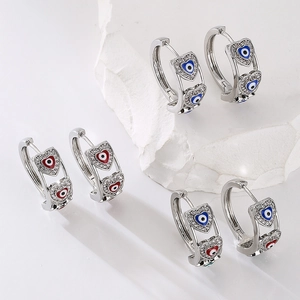 Three pairs of silver hoop earrings with blue, red, and multi-color heart evil eye charms