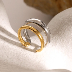 Detailed view of dual-tone polished stainless steel ring on a white stone background