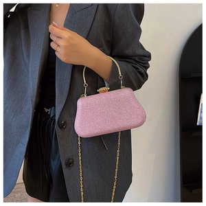 Close-up of pink glitter evening clutch with gold metal ring handle and jewelry clasp