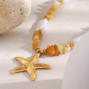 18K gold plated necklace with starfish pendant, orange gemstones and pearls on beach stones