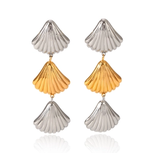Macro shot of three-tier shell earrings in polished gold and silver plated stainless steel