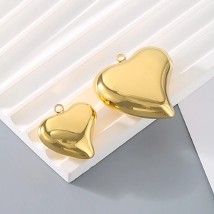 Golden hollow 3D heart pendants in two sizes with a polished mirror finish on a white stand