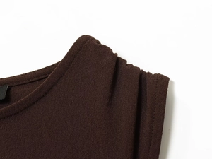 Detailansicht des gefalteten Schulterdesigns und Rundhalsausschnitts am braunen Strickkleid