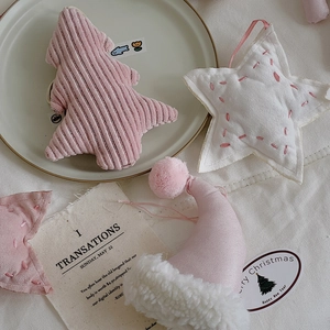 Detail of pink corduroy Christmas tree and white star plush ornaments for DIY decor