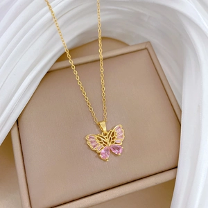 Vue détaillée du collier papillon doré avec cristaux roses sur fond de soie douce