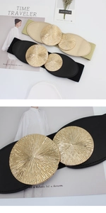 Close-up of golden sunburst metal buckle on a black elastic wide waist belt for women