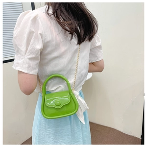 Detail of mini lime green jelly bag with gold chain strap shown on a model