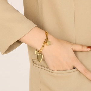 Golden titanium steel bracelet with heart and square charms worn by a model