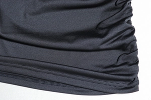 Dettaglio del tessuto in maglia nera con arricciatura laterale e cucitura dell'orlo