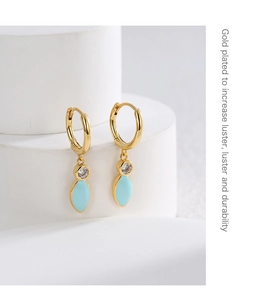 Detailed shot of gold-plated hoops with light blue enamel and clear zircon stones