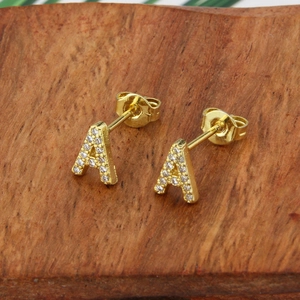 Macro view of gold plated letter A stud earrings with sparkling cubic zirconia stones