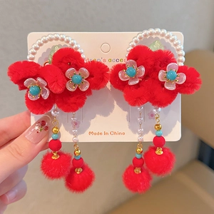 Detail of red plush flower hair clips with pearl beads and blue tassel for kids