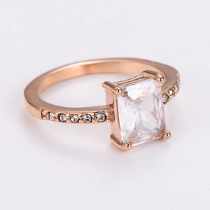 Detail of rose gold ring featuring a rectangular zircon stone and side-set accents