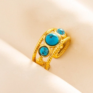 Detail view of gold adjustable ring featuring three blue stones and woven texture design