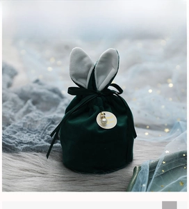 Détail du sac de mariage en velours vert foncé avec oreilles de lapin et perle