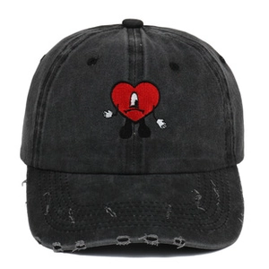 Detail of red cartoon heart embroidery on washed black distressed baseball cap brim