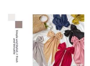 Detail of satin bow hair clips in assorted colors with long ribbons and smooth texture