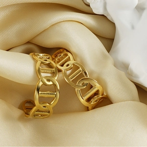 Close-up of 18K gold plated chain link earrings on beige silk fabric with decor