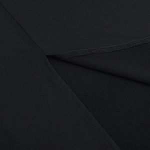 Detailed close-up of ruffle stitching and mesh patchwork on a black elegant dress