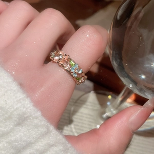 Macro shot of rose gold floral ring with enamel petals and sparkling diamonds