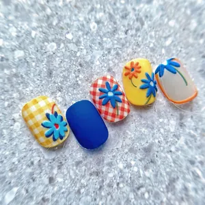 Macro detail of 3D embossed floral nail art with blue plaid and yellow daisy designs