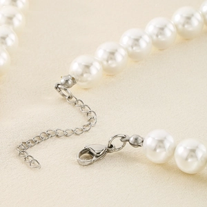 Dettaglio collana di perle bianche con chiusura a moschettone argento e catena regolabile