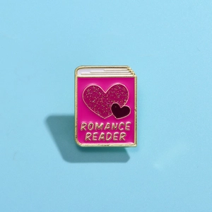 Detail of pink Romance Reader enamel pin badge with glitter heart and gold outlines