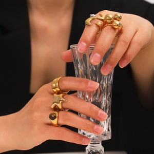 Detailed close-up of gold star and moon rings with tiger eye stone on model hand