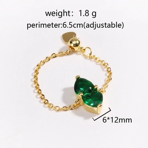 Adjustable gold chain ring with emerald green teardrop crystals in a minimalist style