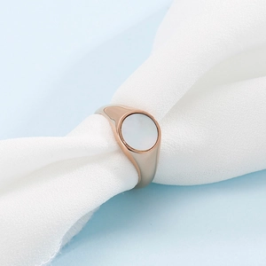 Macro view of rose gold stainless steel ring with white circular shell inlay detail