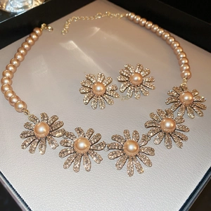 Detail of floral necklace and earrings set with pearls and rhinestones in jewelry box