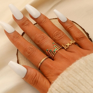 Detailed view of elegant gold ring set with love letter and V-shape gemstone designs