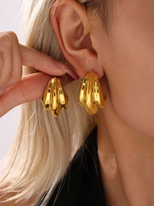 Close-up of model wearing thick gold plated stainless steel chunky hoop earrings
