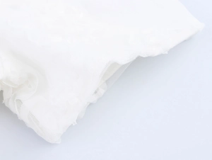 Detailed macro view of delicate white lace mesh fabric and textures for elegant dresses