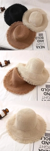 Detail von Strohhüten mit Fransenrand in Schwarz Beige und Braun für den Strand