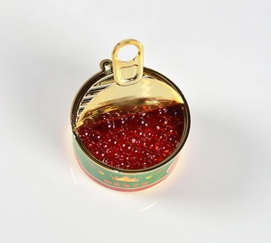 Macro shot of miniature green caviar tin toy featuring realistic red resin beads
