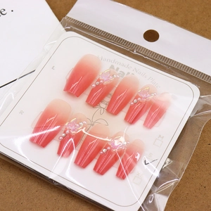 Pink gradient press-on nails with 3D butterflies and pearls on white card