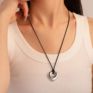 Close-up of silver irregular hollow heart pendant on a black cord necklace for women