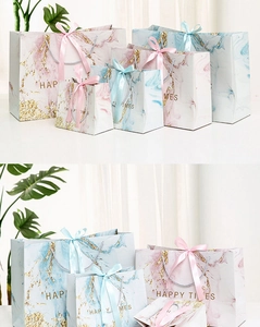 Detailed close-up of marble pattern gift bags with golden accents and ribbon handles