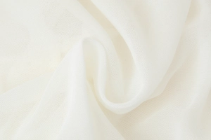 Macro detail of white ruffled mesh fabric showing breathable texture and soft draping