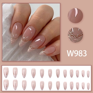 Detail view of W983 nude pink press-on nails with gold edges and long stiletto shape
