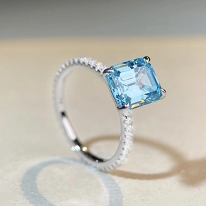 Macro side view of 925 silver ring featuring emerald cut blue gemstone with diamonds