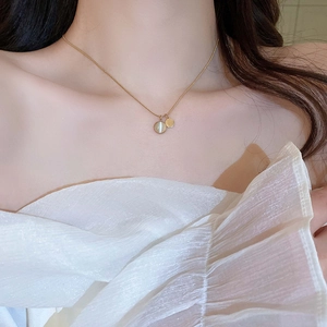 Minimalist gold snake chain necklace with round opal pendant worn by a model