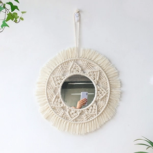 Close-up of bohemian round mirror with ivory cotton tassel weaving and fringe detail