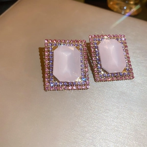 Macro detail of rectangular pink opal earrings with zircon pavé on a golden metallic base